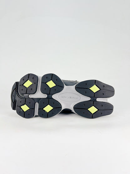 New Balance 9060 sneakers shown are in a black and cement colorway, often featuring a durable mesh and suede construction with Lime accents
