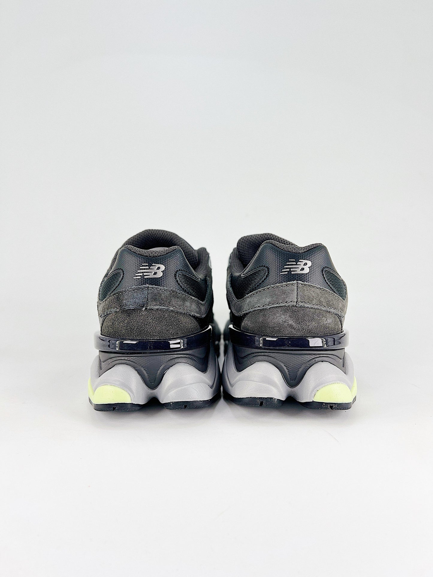 New Balance 9060 sneakers shown are in a black and cement colorway, often featuring a durable mesh and suede construction with Lime accents